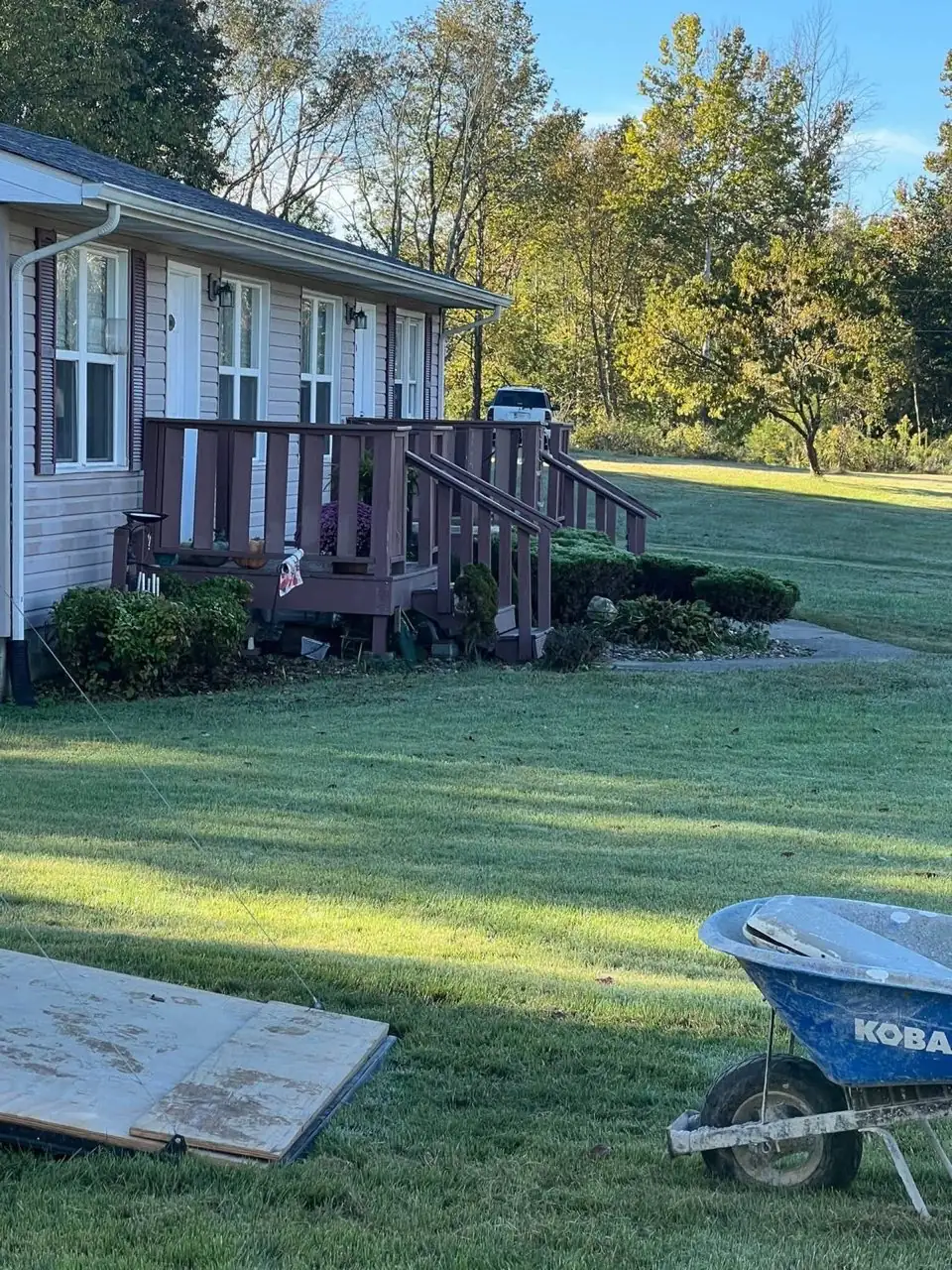 Before: Aged front porch with dark stain and weathered wood