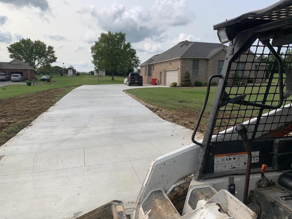 Fresh curved concrete driveway leading to a brick home
